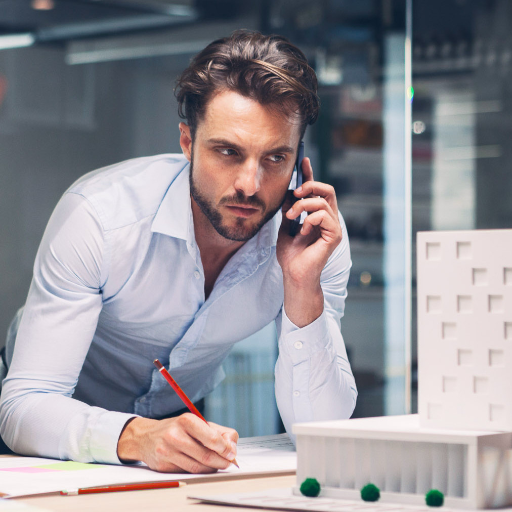Designer talking on smart phone in office.