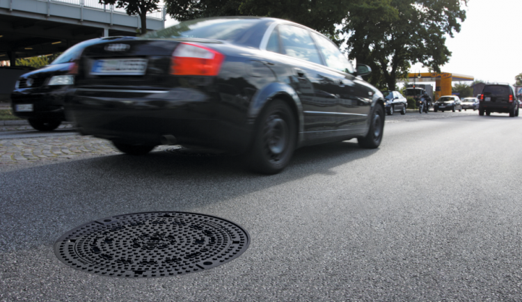 Tampa de inspecção MULTITOP em uma estrada de asfalto com carros