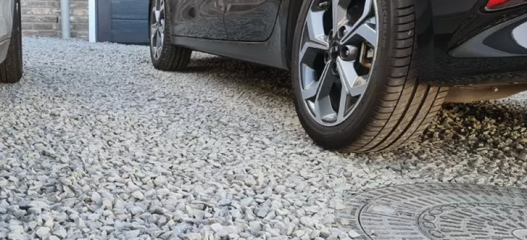 Panal ACO Gravel Grid en la entrada del garaje de una casa, con un coche.